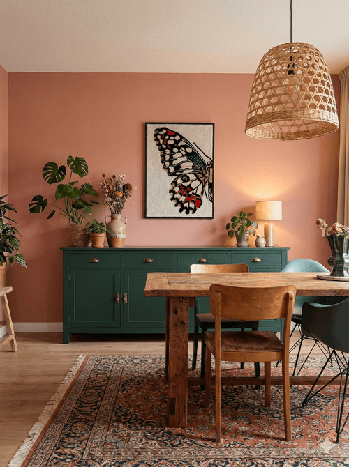 Tufted butterfly wall hanging by Filo Arts displayed in a warm bohemian dining room with terracotta wall, green sideboard and vintage Persian rug