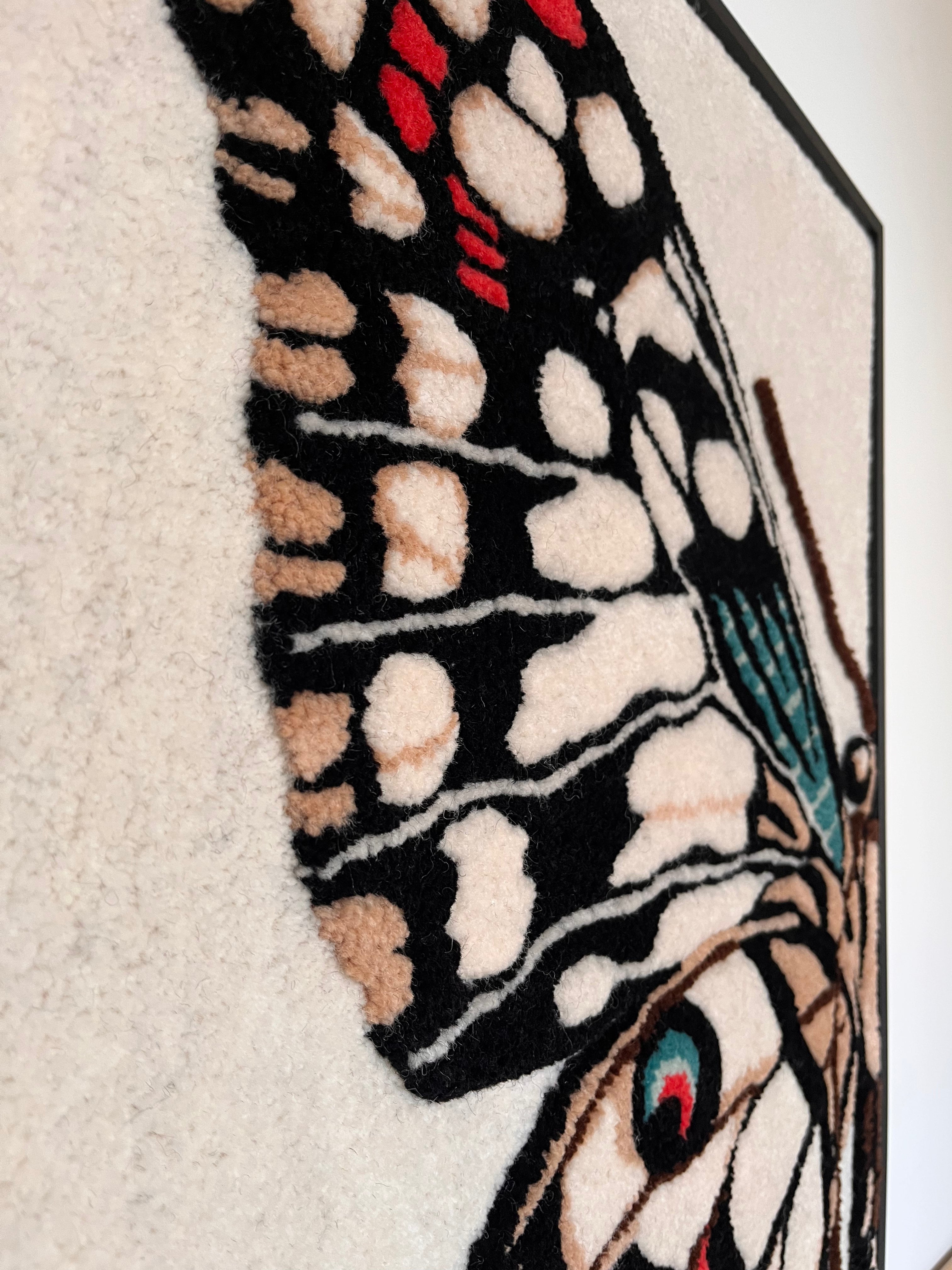 Close-up detail of tufted Butterfly wall hanging showing the handcrafted wool texture of the wing pattern in black, cream, red and teal